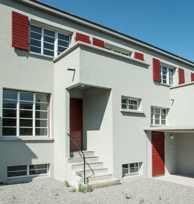 Meilihaus, Feldbreite Emmenbrücke Luzern.  Stoffel Schneider Architekten AG.   Der Vorbau für den Eingang und die Toilette gliedert die Fassade und das Gesamtvolumen. Die Fensterteilung mit den schlanken Glassprossen sind den Originalfenstern abgenommen und nachgebaut. Die dunkelroten Klappläden sind die Originalläden und  konnten saniert und aufgefrischt werden.