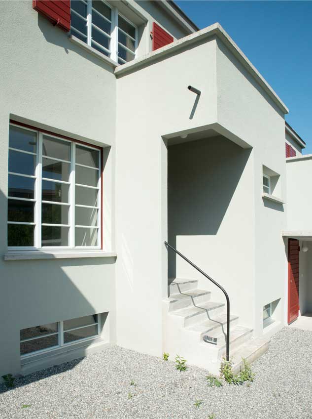 Meilihaus, Feldbreite Emmenbrücke Luzern.  Stoffel Schneider Architekten AG.   Der Vorbau für den Eingang und die Toilette gliedert die Fassade und das Gesamtvolumen. Die Fensterteilung mit den schlanken Glassprossen sind den Originalfenstern abgenommen und nachgebaut. Die dunkelroten Klappläden sind die Originalläden und  konnten saniert und aufgefrischt werden.