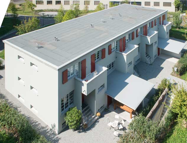 Meilihaus, Feldbreite Emmenbrücke Luzern.  Stoffel Schneider Architekten AG.  Auf dieser Luftaufnahme ist die Volumentrie mit dem Flachdach, den Vorbauten für die Eingänge sowie die frei auskragenden Flugdächer gut zu erkennen.