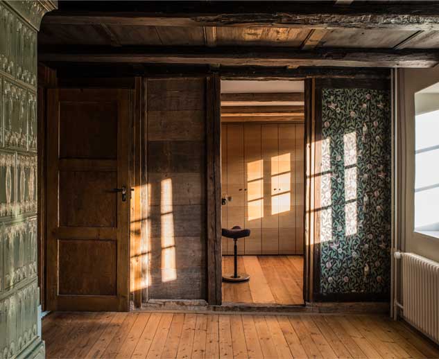 **Schrankraum Taunerhaus Hörhausen** Die alte Stube des Kleinbauernhauses oder Taunerhauses in Hörhausen mit dem Kachelofen und den alten Blumentapeten wurde zum Schlafzimmer der Eltern. Die kleine Nebenkammer wurde zum Schrankraum.