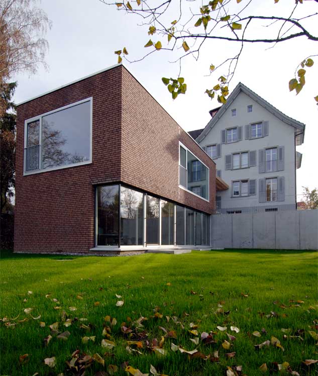 **Wohnheim Im Kanzler, Frauenfeld TG** Das Hauptgebäude des Wohnheimes stammt aus den 1920er Jahre. Es war als Wohnhaus mit Geschosswohnungen gebaut. Für die Einrichtung des Wohnheims wurde die Wohnung im Hochparterre zum Wohnteil und die beiden Wohnungen des Obergeschosses und des Dachgeschosses behinhaltete die Individualzimmer. Mit dem zweigeschossigen Anbau konnten die Wohnräume aus dem Hochparterre in den Anbau verlegt und das Erdgeschoss zu weiteren Bewohnerzimmer umgebaut werden. Mit dem Umbau wurde ein Zimmer aufgehoben und zu zwei Badezimmern umgebaut. Das durch die Hanglage des Anbaus vollständig freigelegte Untergeschoss wird als Mehrzweck und Arbeitsraum genutzt. Die Fassade des Anbaus ist in Sichtbackstein gebaut. Dadurch erhällt sie einen ausgesprochenen Langlebigkait und sehr geringe Unterhaltsarbeiten.